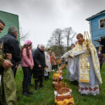 An Orthodox priest sprinkles holy water during the Orthodox Easter service next to The Nativity of the Holy Virgin Church damaged by shelling in the village of Peremoha, Ukraine on April 24.