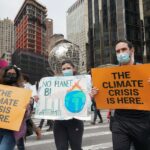 NYC climate protesters block intersection, climb on top of subway station